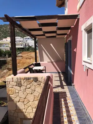 a patio with a bench and a table on a building at Pink House in Palaiochóra
