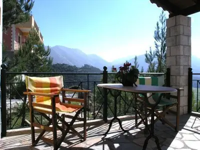 a patio with a table and two chairs on a balcony at Panorama Askifou in Karés