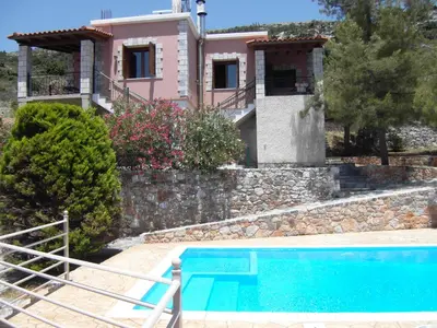 a villa with a swimming pool in front of a house at Panorama Askifou in Karés