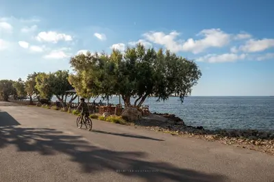 a person riding a bike down a road next to the water at Alexandros Luxury House in Falasarna