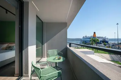 a balcony with a table and chairs and a view of the ocean at Souda Plaza Collection in Souda