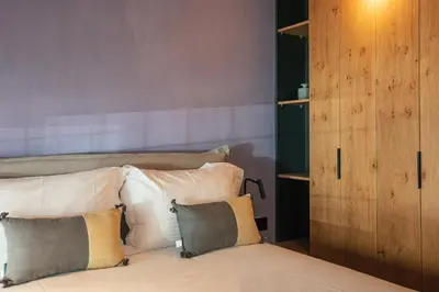 a bedroom with a bed with pillows and a wooden cabinet at Souda Plaza Collection in Souda