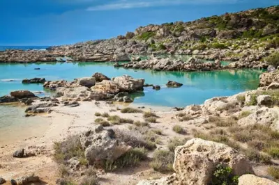 a view of a beach with rocks and blue water at Elafonisi Vacation Blue Apartment in Agios Padeleimon