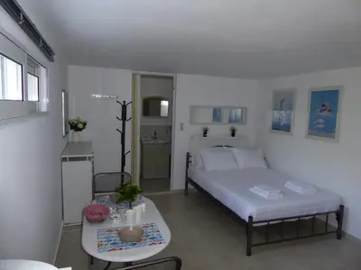 a small bedroom with a bed and a table at Elafonisi Vacation Green Studio in Agios Padeleimon