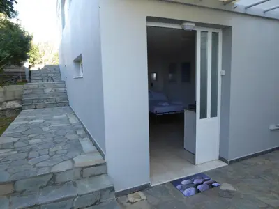 a door leading to a patio with a stone pathway at Elafonisi Vacation Green Studio in Agios Padeleimon