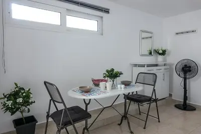 a white table and chairs in a white room at Elafonisi Vacation Green Studio in Agios Padeleimon