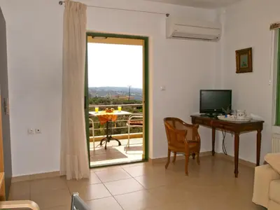 a living room with a door open to a patio at The Garden of Zephyrus - East in Pithárion