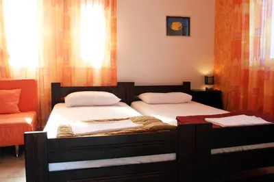 two twin beds in a room with a window at Kouros Chania Villas in Maleme