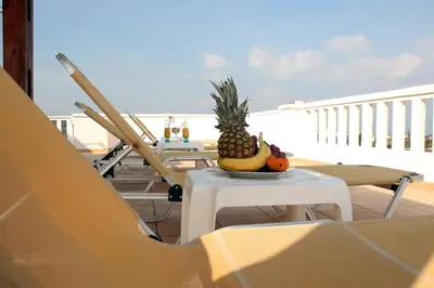 a pineapple and other fruit on a table on a balcony at Kouros Chania Villas in Maleme