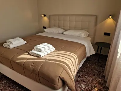 a bedroom with a large bed with towels on it at Mosaic Apartments in Chania Town