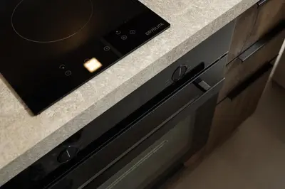 a black stove top oven sitting under a counter at KOEV slow living in Tsikalariá