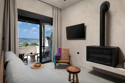 a living room with a couch and a fireplace at KOEV slow living in Tsikalariá