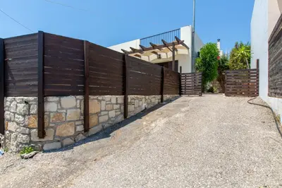 a wooden fence in front of a house at Villa Henry Darmarohori in Darmarochori
