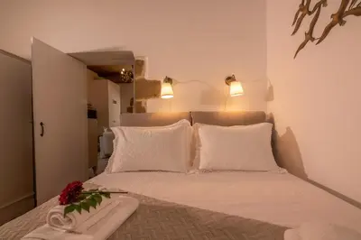 a bedroom with a bed with white pillows and flowers on it at Pool Villa Michail, in Kissamos! in Koukounará