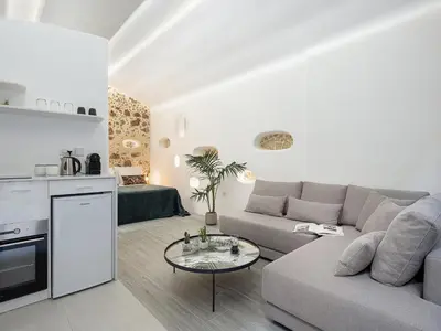 a living room with a couch and a table at Malmáki, a street view apartment in Chania Town