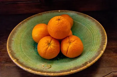 a bowl of oranges on a wooden table at History & Culture in Old Town Chania in Chania Town