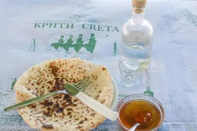 a table with a plate of food and a bottle of wine at History & Culture in Old Town Chania in Chania Town
