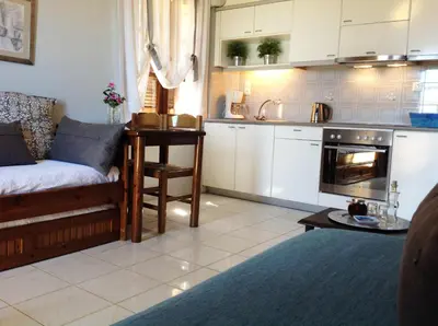 a living room with a couch and a kitchen at Asterias Studios & Apartments in Kalyves