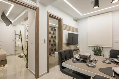 a dining room with a table and chairs and a television at Pi Suite Project Smart Living in Chania Town