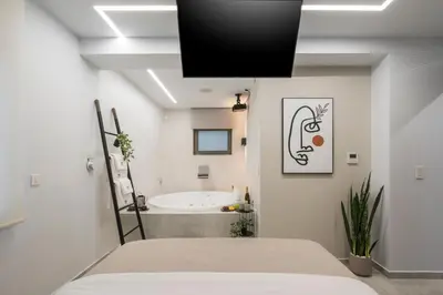 a bathroom with a tub and a bed in a room at Pi Suite Project Smart Living in Chania Town