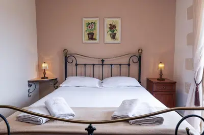 a bedroom with a bed with white sheets and two lamps at Giovanta Villa in Kondomari