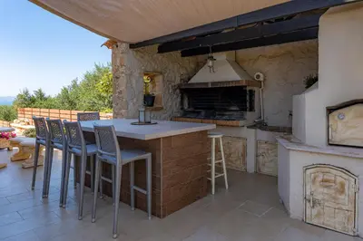 an outdoor kitchen with a counter and stools at Giovanta Villa in Kondomari