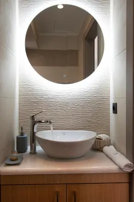 a bathroom with a sink with a round mirror at Villas Libra in Falasarna