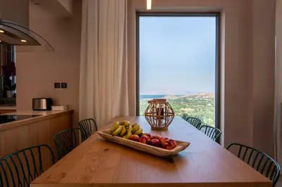 a bowl of fruit on a wooden table with a window at Villas Libra in Falasarna