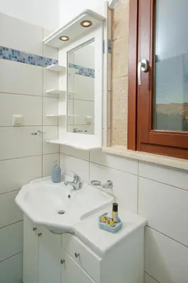 a white bathroom with a sink and a mirror at Villas Libra in Falasarna