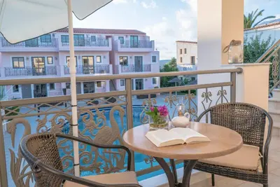 a table with an open book on a balcony at Flamingos Hotel Apartments in Kato Daratso