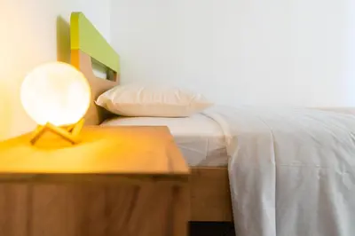 a bedroom with a bed with a table with a lamp at Peggy's apartment in Chania in Chania Town