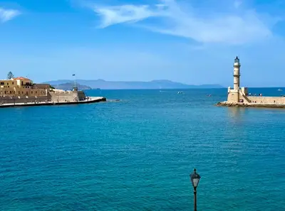 a lighthouse in the middle of a body of water at Tersanas Beach Apartments in Chorafakia