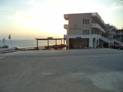 a building on the beach next to the ocean at Falasarna Bay in Falasarna