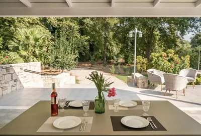 a table with plates and wine glasses on a patio at Villa Nature, Heated Pool in Kalyves