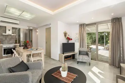 a living room with a couch and a table at Villa Nature, Heated Pool in Kalyves