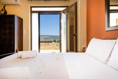 a bedroom with a large white bed with a view at Villa Leon in Souda