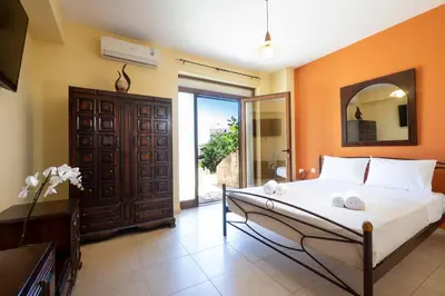 a bedroom with a large bed and a mirror at Villa Leon in Souda