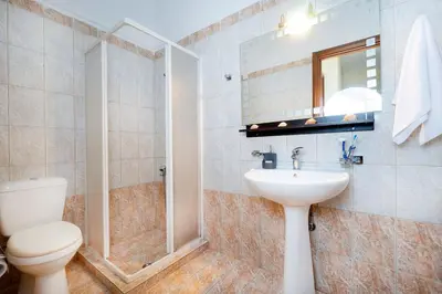 a bathroom with a toilet and a sink and a mirror at Villa Leon in Souda
