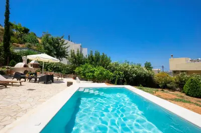 a swimming pool with blue water in a yard at Villa Leon in Souda