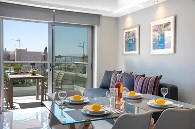 a dining room with a glass table and chairs at Sunshine Suite Family in Chania Town