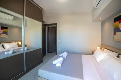 a bedroom with a large bed with towels on it at Sunshine Suite Family in Chania Town
