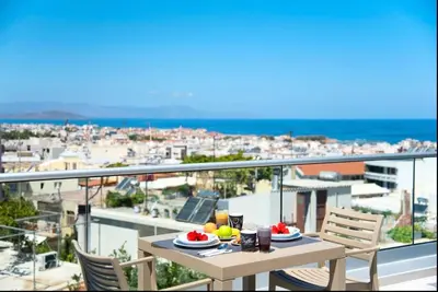 a table on a balcony with a view of the ocean at Sunshine Suite Family in Chania Town