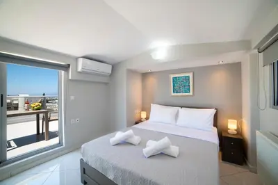 a bedroom with a large bed and a large window at Sunshine Suite Family in Chania Town