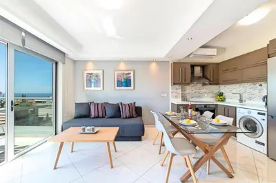 a kitchen and living room with a table and a couch at Sunshine Suite Family in Chania Town