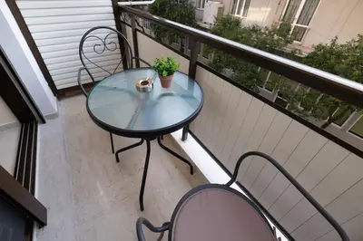 a glass table and chairs on a balcony at Eleni's apartment in the center of Chania in Chania Town
