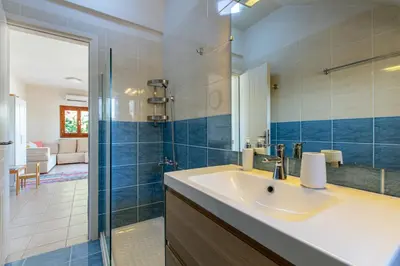 a bathroom with a sink and a glass shower at Villa Daya in Darmarochori