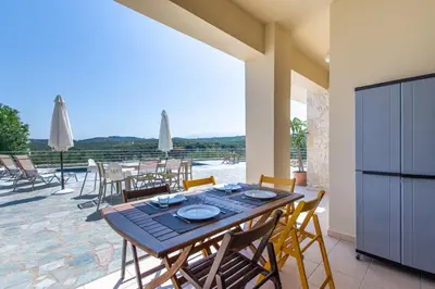 a dining room with a table and chairs on a patio at Villa Daya in Darmarochori