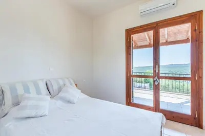 a white bed in a room with a window at Villa Daya in Darmarochori