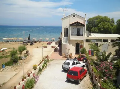 a house with a red car parked next to the beach at 'Sky and Sea 1' Apartment in Kato Daratso