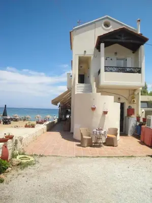a white building with a balcony and the ocean at 'Sky and Sea 1' Apartment in Kato Daratso